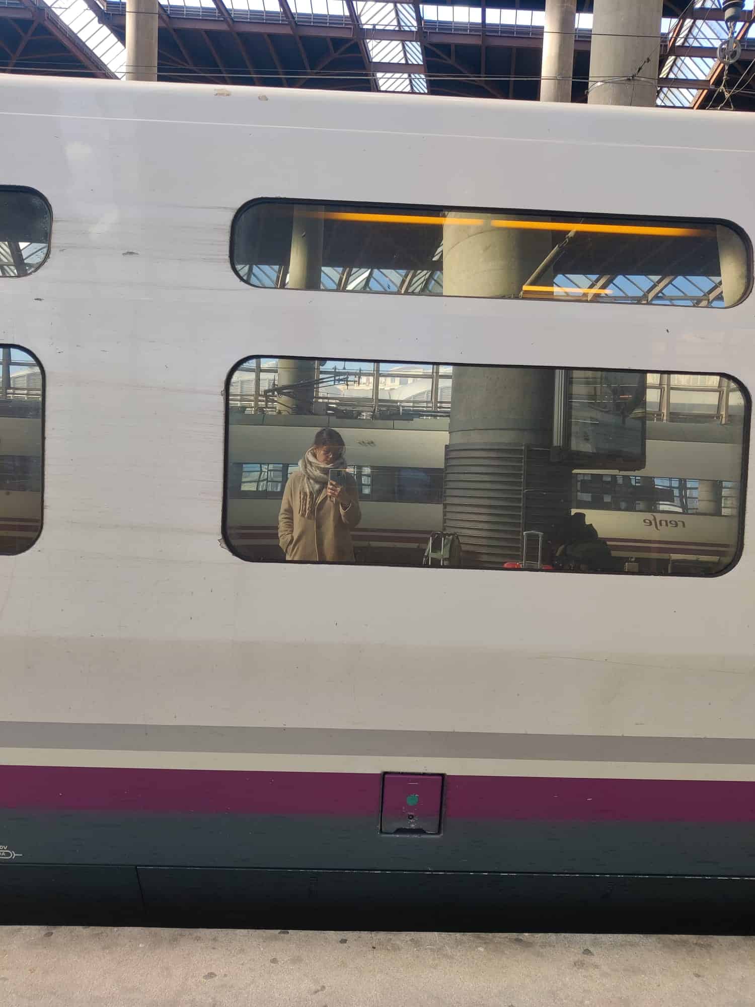 Helena Calvo stands opposite a Renfe AVE train at a platform
