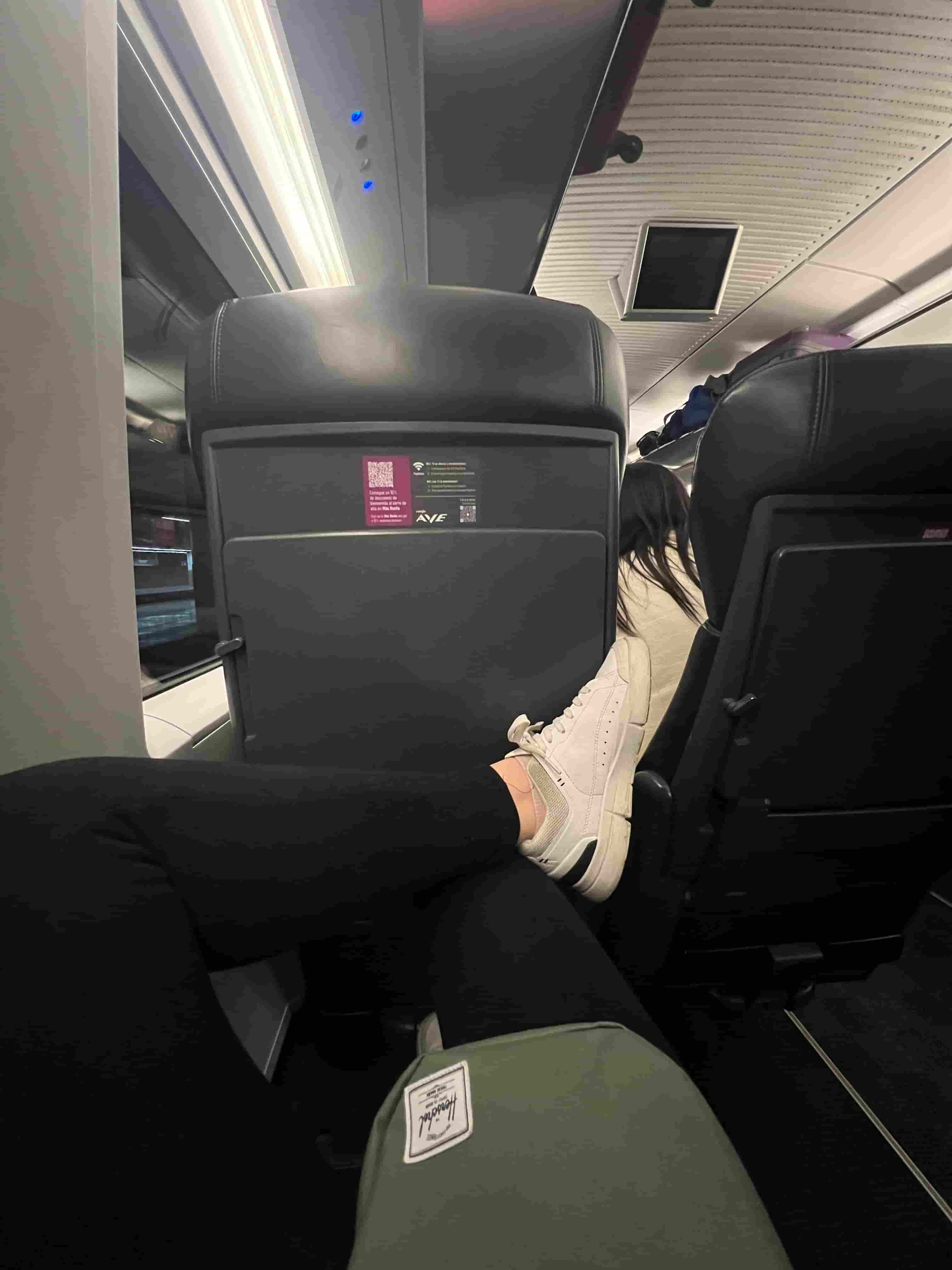 Sitting on board a Renfe AVE train - you can see the legroom available as the woman in the photo sits slouched, with her legs crossed