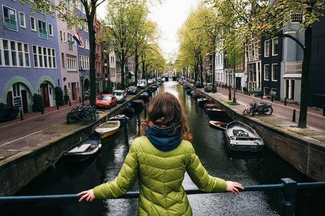 A woman looking down a canal in Amsterdam