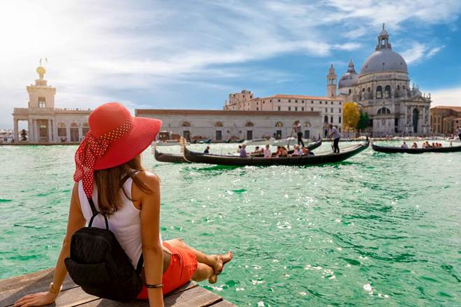 Female tourist looking the Basilica di Santa Maria della Salute and Canale Grande in Venice, Italy