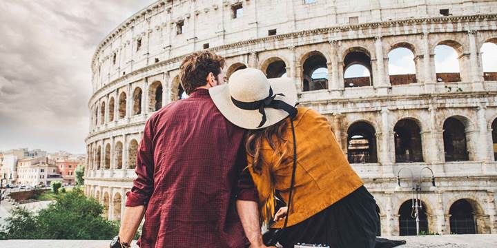 Couple of tourists on vacation in Rome looking at the Colosseum