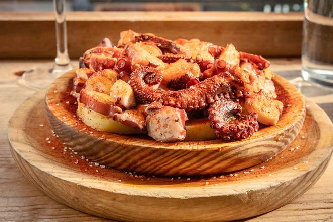 Pulpo a la gallega, traditional Spanish octopus dish, served in the typical wooden bowl
