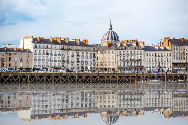 Beautiful riverside view with old buildings and Notre Dame cathedral in Nantes city in France