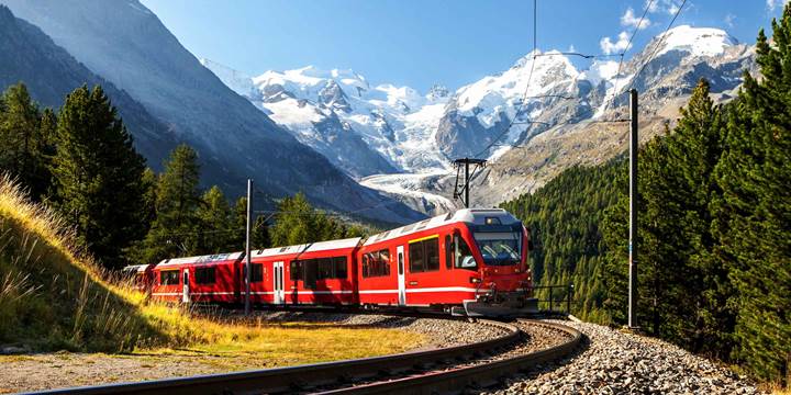 Swiss train with the Alps mountains in the background near Ospizio Bernina
